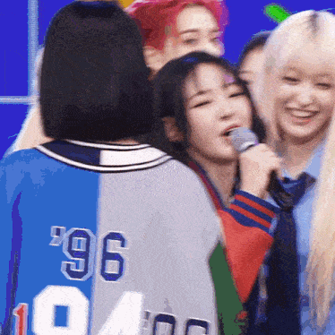 a girl wearing a number 96 jersey holds a microphone