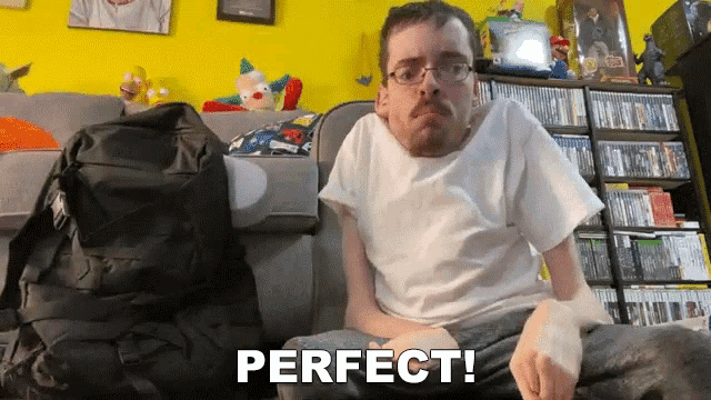 a man with glasses is sitting on a couch with the word perfect written on the bottom