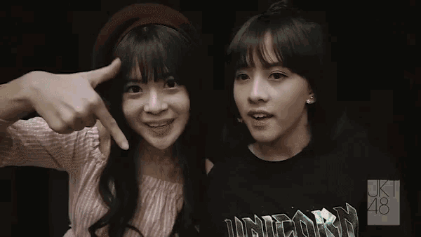 two girls are posing for a picture and one has a shirt that says unicorn on it