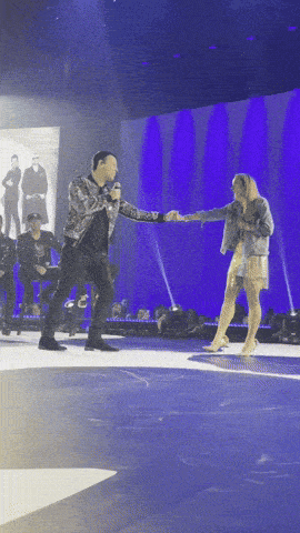 a man and a woman are dancing on a stage in front of a crowd