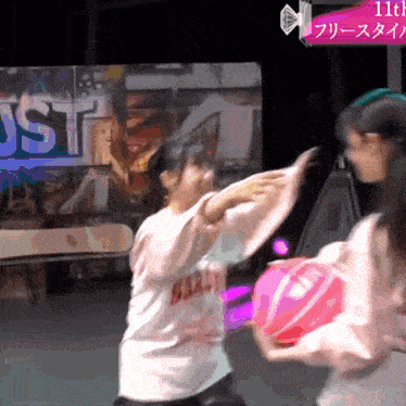 two girls are playing with a ball in front of a sign that says 11th on it