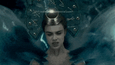 a woman is wearing a crown on her head with her eyes closed and a fan on her head .