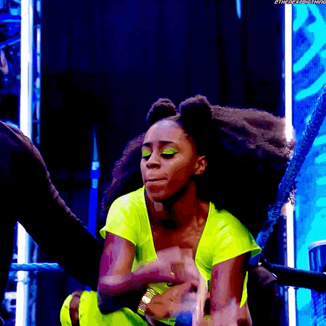 a woman in a neon green outfit is sitting in a ring