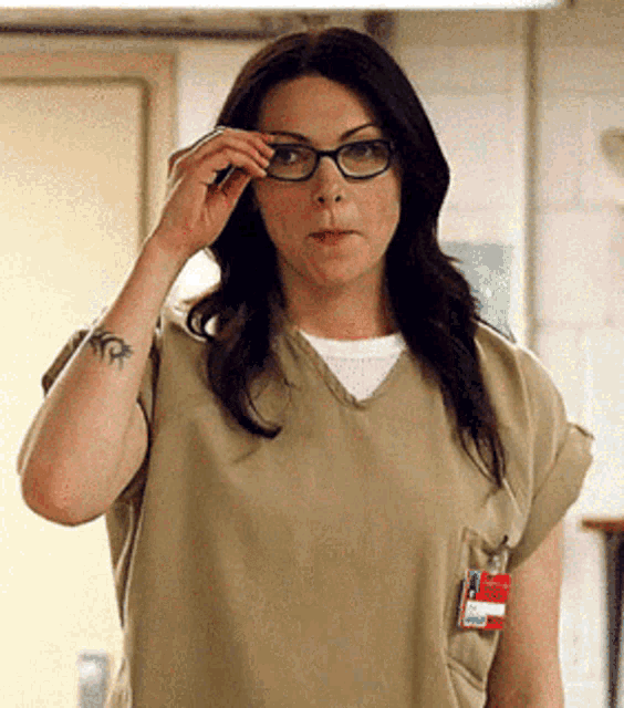 a woman wearing glasses is adjusting her glasses in a room