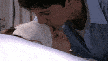 a man kisses a woman in a hospital bed with a bandaged head