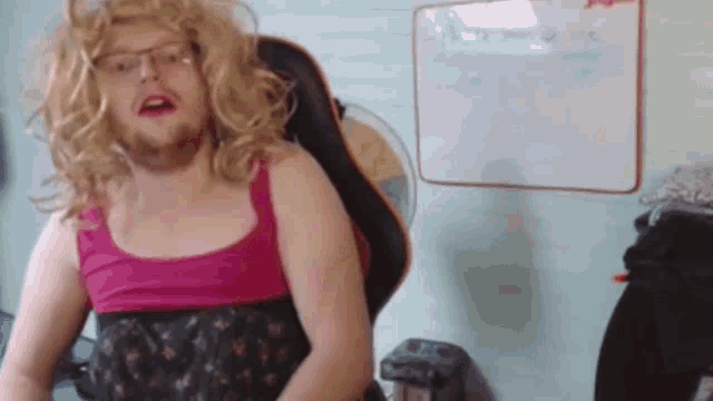 a man with a beard and blonde hair is sitting in a chair .