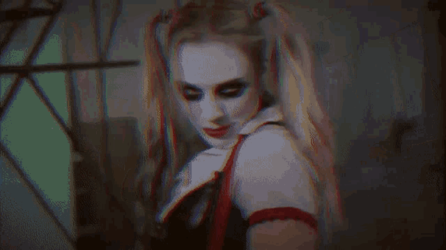 a woman is wearing a harley quinn costume and looking at the camera .