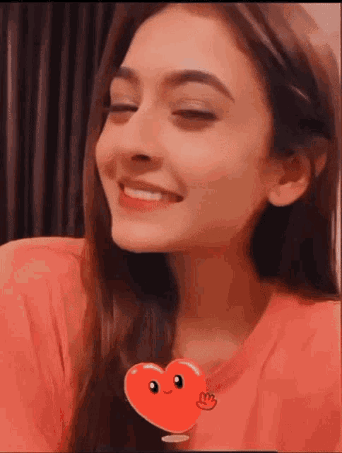 a close up of a woman 's face with a red heart sticker on it .