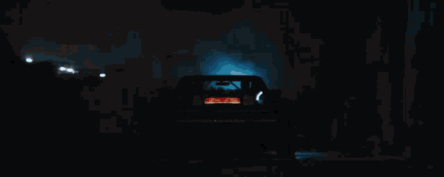 a car is driving down a road at night with the hood up