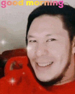 a man in a red shirt is smiling with the words good morning written above him