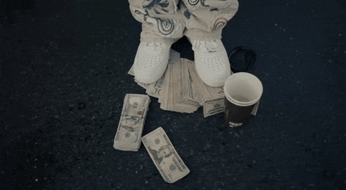 a man in a hoodie holds a bottle of water in front of a motel