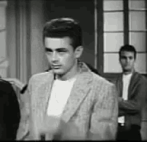 a man in a suit is standing in a room with two other men