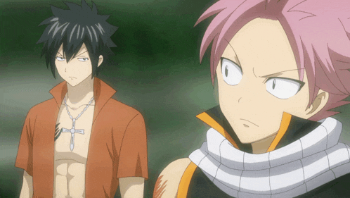 a man with a cross on his chest is standing next to another man with pink hair