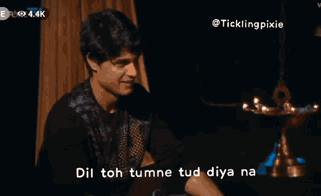 a man sitting in front of a lamp with the words dil toh tumne tud diya na above him