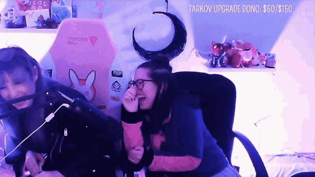 two girls are laughing in front of a screen that says tarkov upgrade dono