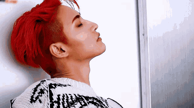a man with red hair is wearing a sweater