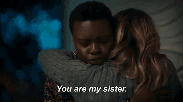 a man and a woman are hugging each other in a dark room .