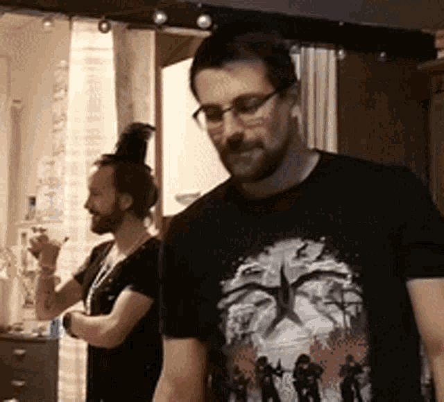 a man wearing glasses and a black shirt with a picture of a man on it
