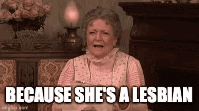 an elderly woman is sitting in front of a fireplace with the words " because she 's a lesbian " above her
