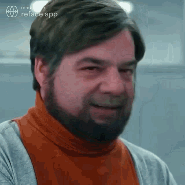a man with a beard wearing an orange turtleneck sweater