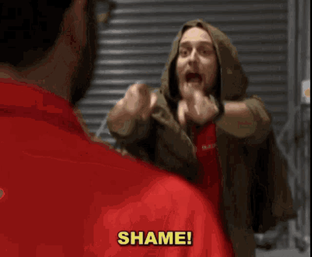 a man wearing a red shirt and a green jacket with the word reebok on it