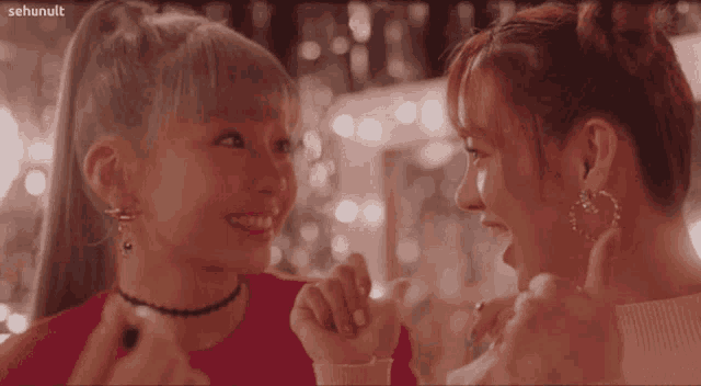 two girls are looking at each other and giving a thumbs up sign