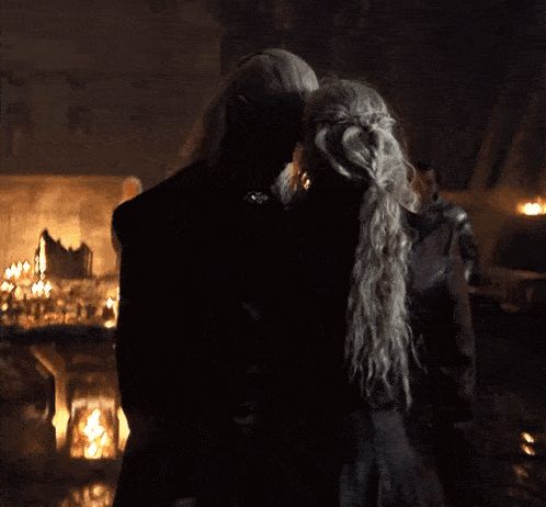 a man and a woman are kissing in a dark room .