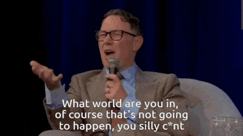 a man speaking into a microphone and saying what world are you in of course that 's not going to happen you silly