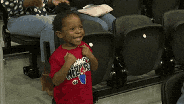 a little boy wearing a shirt that says wizards on it