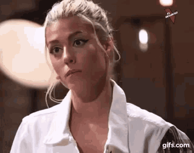 a woman with blonde hair is wearing a white shirt and a black jacket .