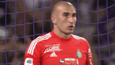 a soccer player wearing a red jersey with the word mister on it