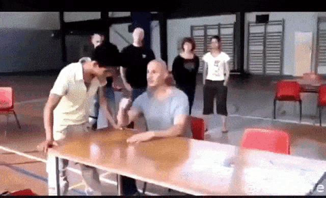 a group of people are standing around a table and one of them is wearing a shirt that says ' e '