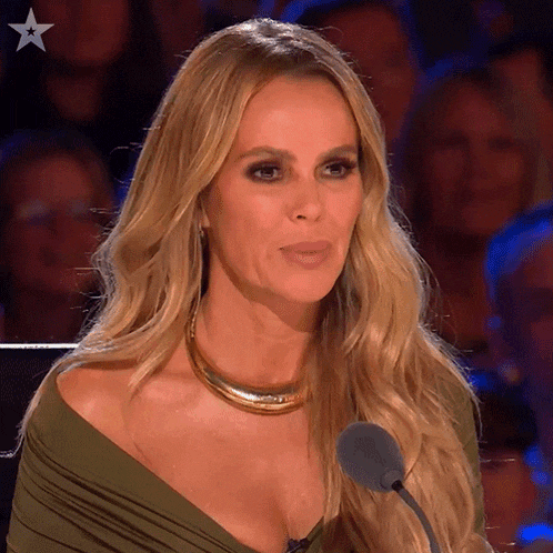 a woman in a green dress stands in front of a microphone with a star in the background