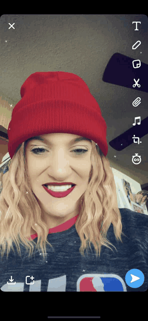 a woman wearing a red beanie and red lipstick smiles for a photo