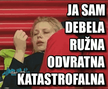 a woman is sitting in a stadium with the words ja sam debela ruzna odvratna katastrofalna on the bottom