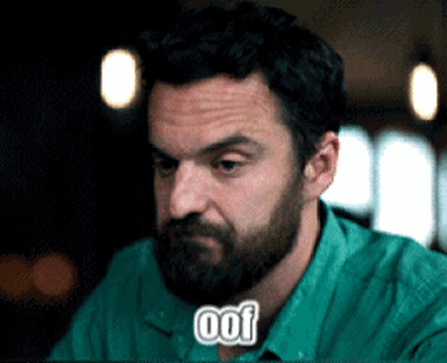 a man with a beard is wearing a green shirt with the word oof written on it