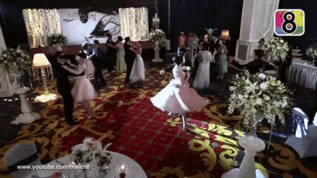 a group of people are dancing in a room with the number 8