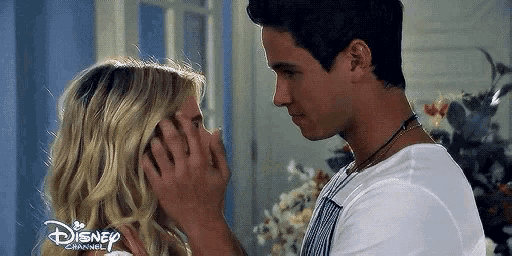 a man and woman are touching each other 's faces in a room .