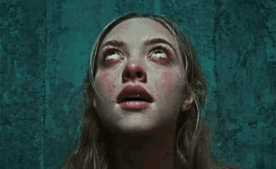 a close up of a woman 's face with blood running down her eyes .