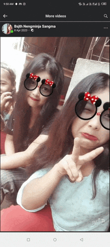 two girls wearing minnie mouse glasses pose for a photo