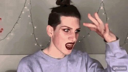 a woman with a bun on her head is making a funny face with her hand .