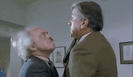 two men in suits and ties are having a conversation