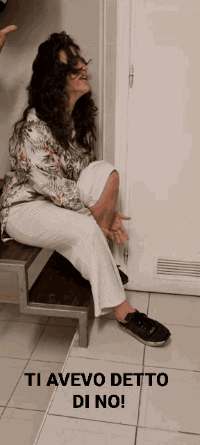 a woman sitting on a bench with the words ti avevo detto di no on the floor
