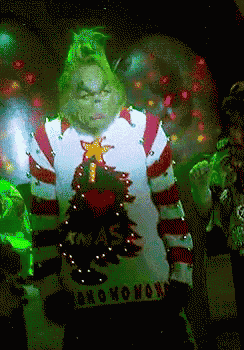 a grinch wearing an ugly christmas sweater with a christmas tree on it