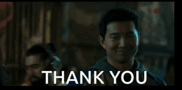 a man is smiling and saying thank you in front of a crowd of people .