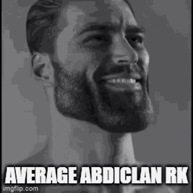 a man with a beard is smiling in a black and white photo with a caption .