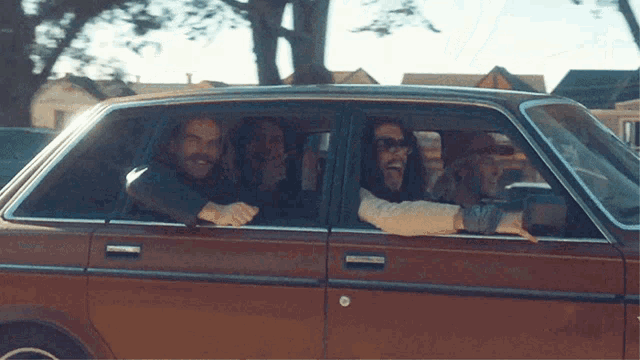 a group of men are sticking their tongues out of the windows of a car