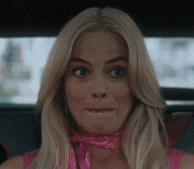 a woman with blonde hair and a pink scarf around her neck makes a funny face