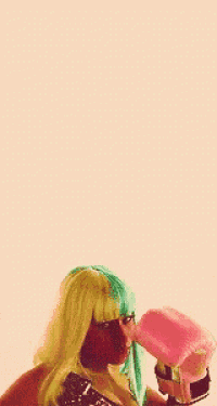 a woman in a yellow and green wig is wearing pink boxing gloves on a polka dot background .