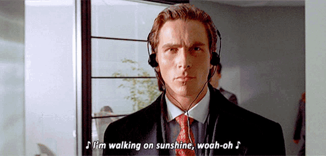 a man in a suit and tie is wearing headphones and says i 'm walking on sunshine woah-oh